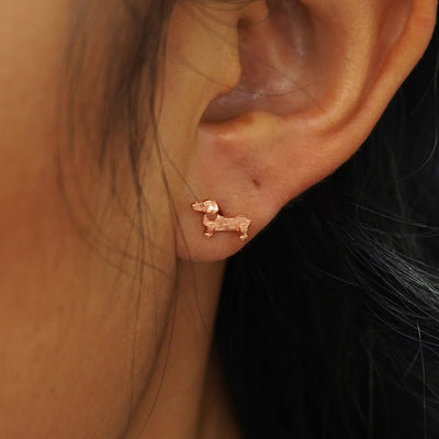 Close up view of a model's ear with a rose gold Dog Earring.