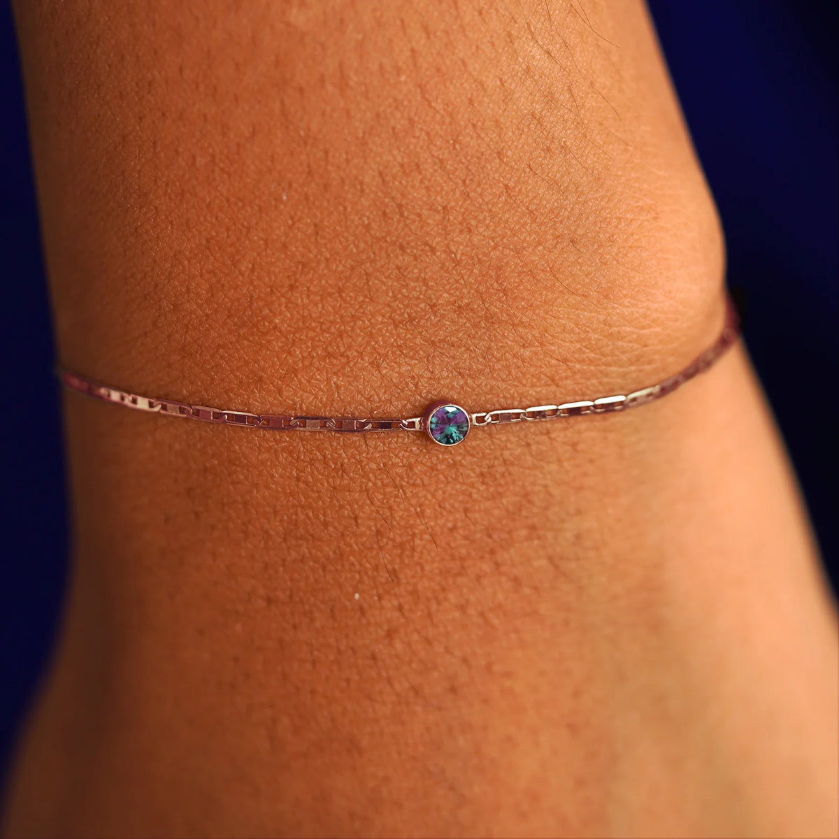 A model's wrist wearing a 14 karat rose gold Alexandrite Bracelet