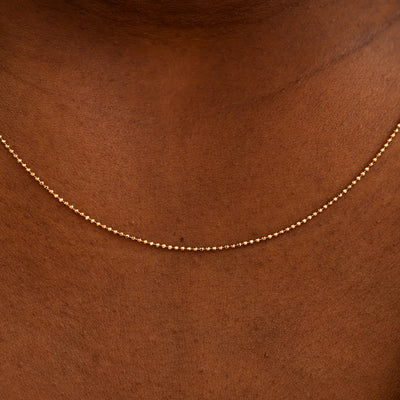 Close up view of a model's neck wearing a solid rose gold Bead Chain