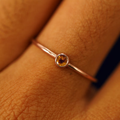Close up view of a model's fingers wearing a 14k rose gold Citrine Ring