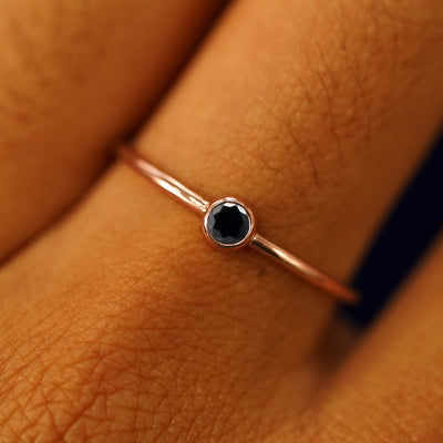 Close up view of a model's fingers wearing a 14k rose gold Black Diamond Ring