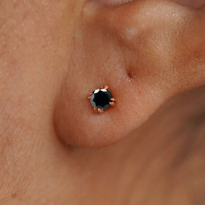 Close up view of a model's ear wearing a 14k rose gold Onyx Earring