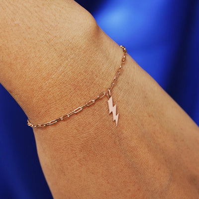 Close up view of a model's wrist wearing a rose gold Lightning Bolt Charm on a Butch Chain Bracelet