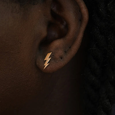 Close up view of a model's ear wearing a 14k rose gold Lightning Bolt Earring