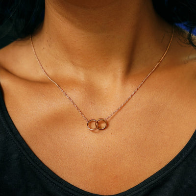 A model's neck wearing a rose gold Bound Together Necklace