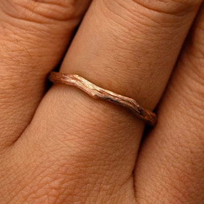 Close up view of a model's fingers wearing a 14k rose gold Branch Band