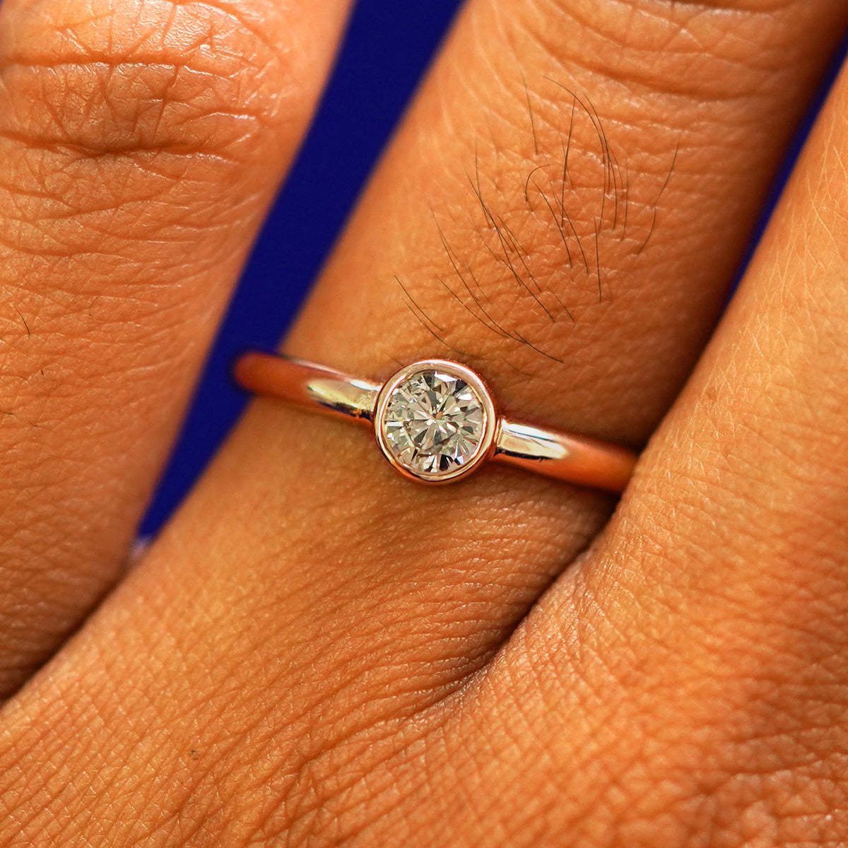 Close up view of a model's fingers wearing a 14k rose gold 1/3ct Diamond Ring