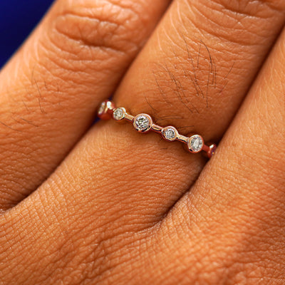 Close up view of a model's fingers wearing a 14k rose gold Infinity Diamond Ring