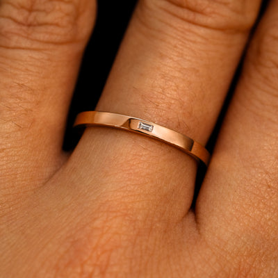 A 14k rose gold Flush Set Baguette Diamond Ring on a model's finger