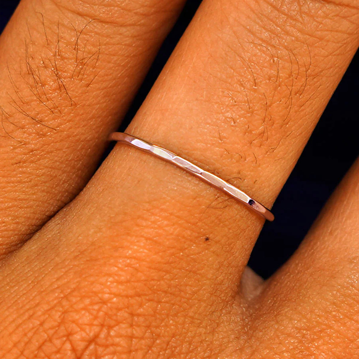 Close up view of a model's fingers wearing a 14k rose gold Hammered Ring