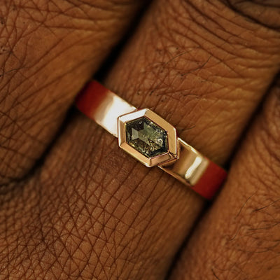 Close up view of a model's hand wearing a solid rose gold Hexagon Diamond Band
