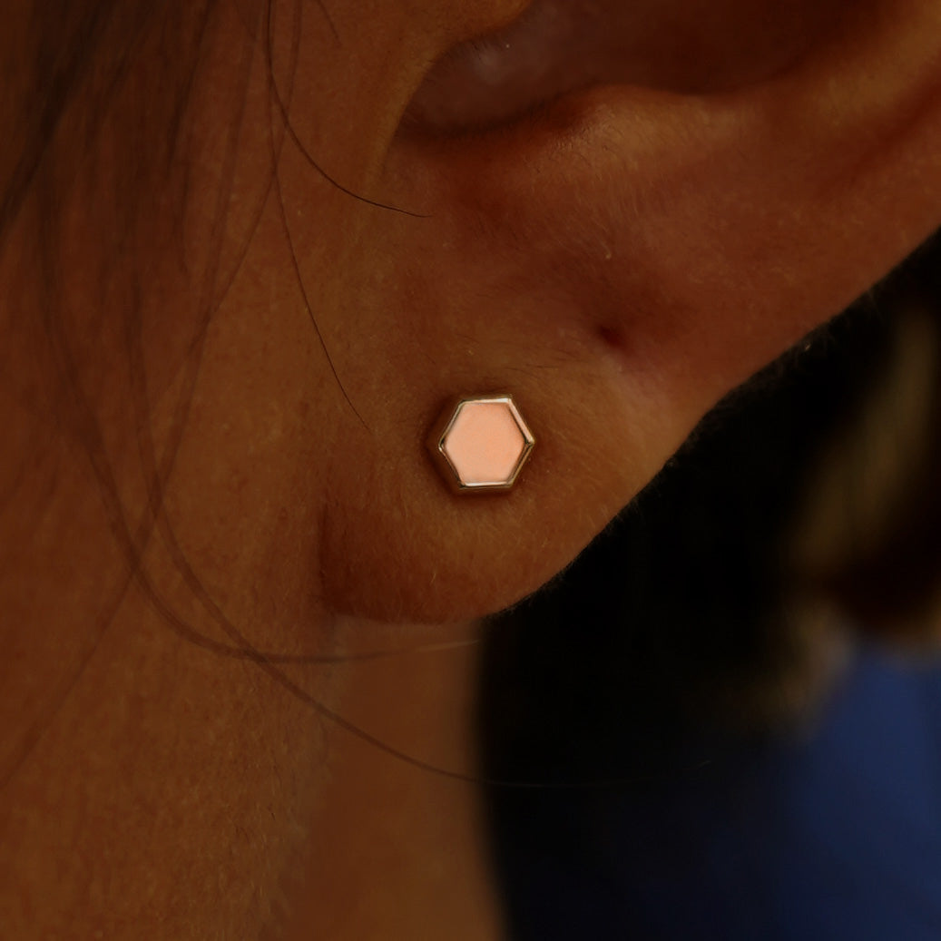 Close up view of a model's ear wearing a rose gold Hexagon Earring