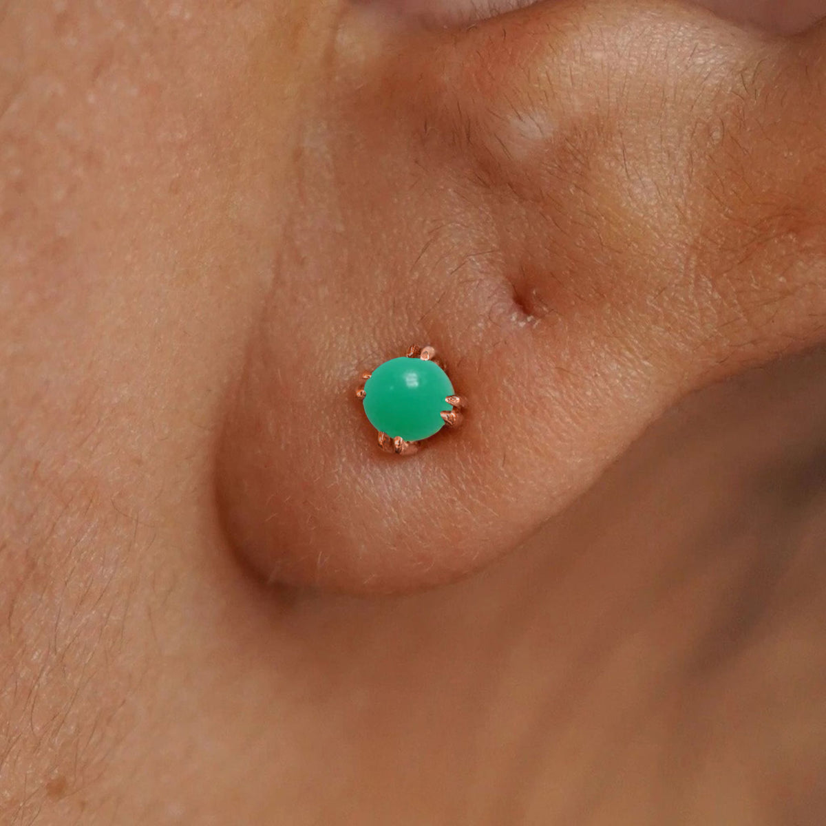 Close up view of a model's ear wearing a 14k rose gold Green Jade Earring