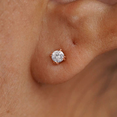Close up view of a model's ear wearing a 14k rose gold Diamond Earring