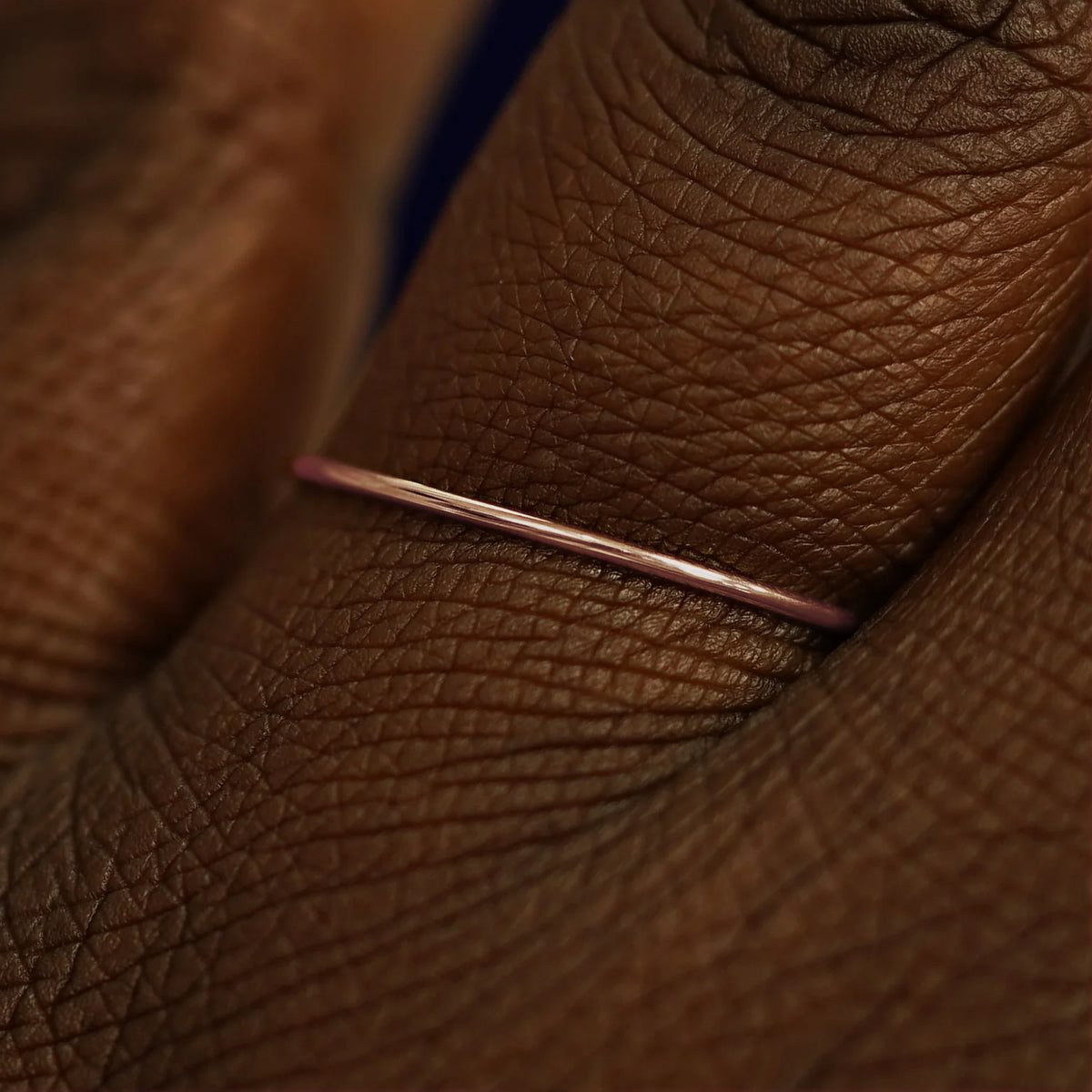 Close up view of a model's fingers wearing a 14k rose gold Line Ring