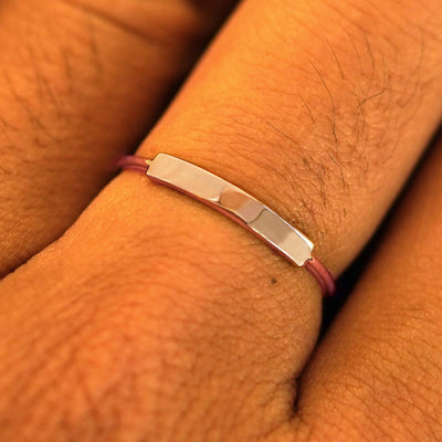 Close up view of a model's fingers wearing a rose gold Bar Ring