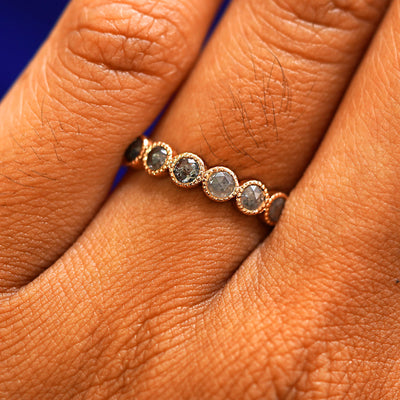 Close up view of a model's hand wearing a 14k rose gold Milgrain Diamond Band