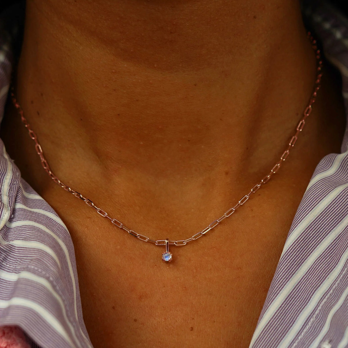 Close up view of a model's neck wearing a rose gold Moonstone Charm on a Butch Chain
