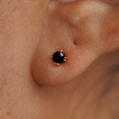 Close up view of a model's ear wearing a 14k rose gold Onyx Earring