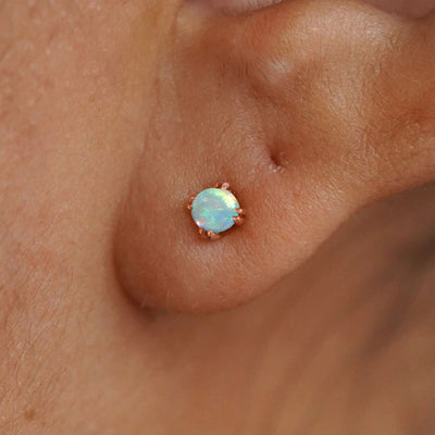 Close up view of a model's ear wearing a 14k rose gold Opal Earring