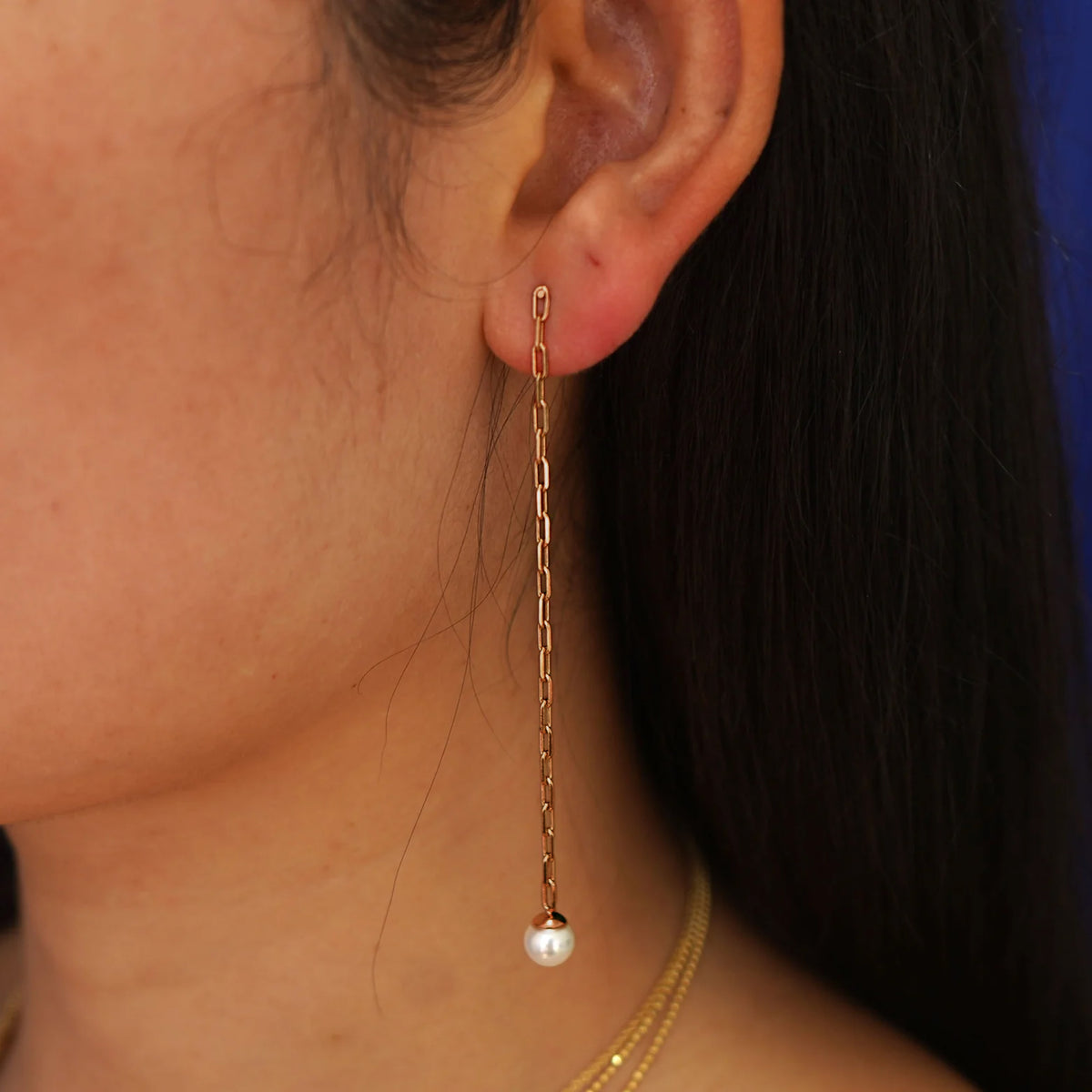 Close up view of a model's ear wearing a 14 karat rose gold Pearl Dangle Earring
