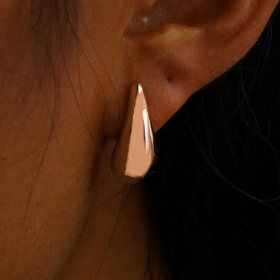 Close up view of a model's ear wearing a rose gold black 5mm Moissanite Earring