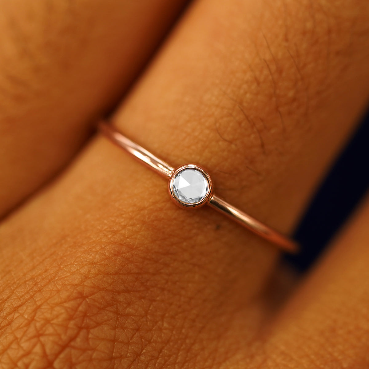 Close up view of a model's fingers wearing a 14k rose gold Rose Cut Diamond Ring