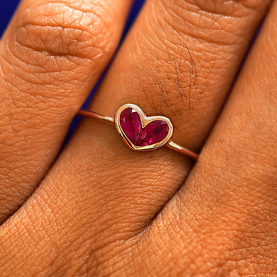 Close up view of a model's fingers wearing a 14k rose gold Ruby Heart Ring