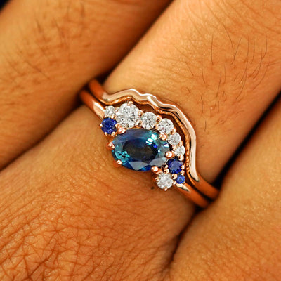 Close up view of a model's fingers wearing a 14k rose gold Sapphire and Diamond Cluster Ring Set