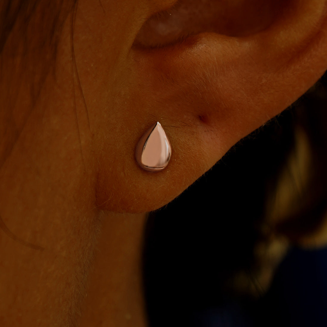 A model's ear wearing a 14k rose gold Teardrop Earring