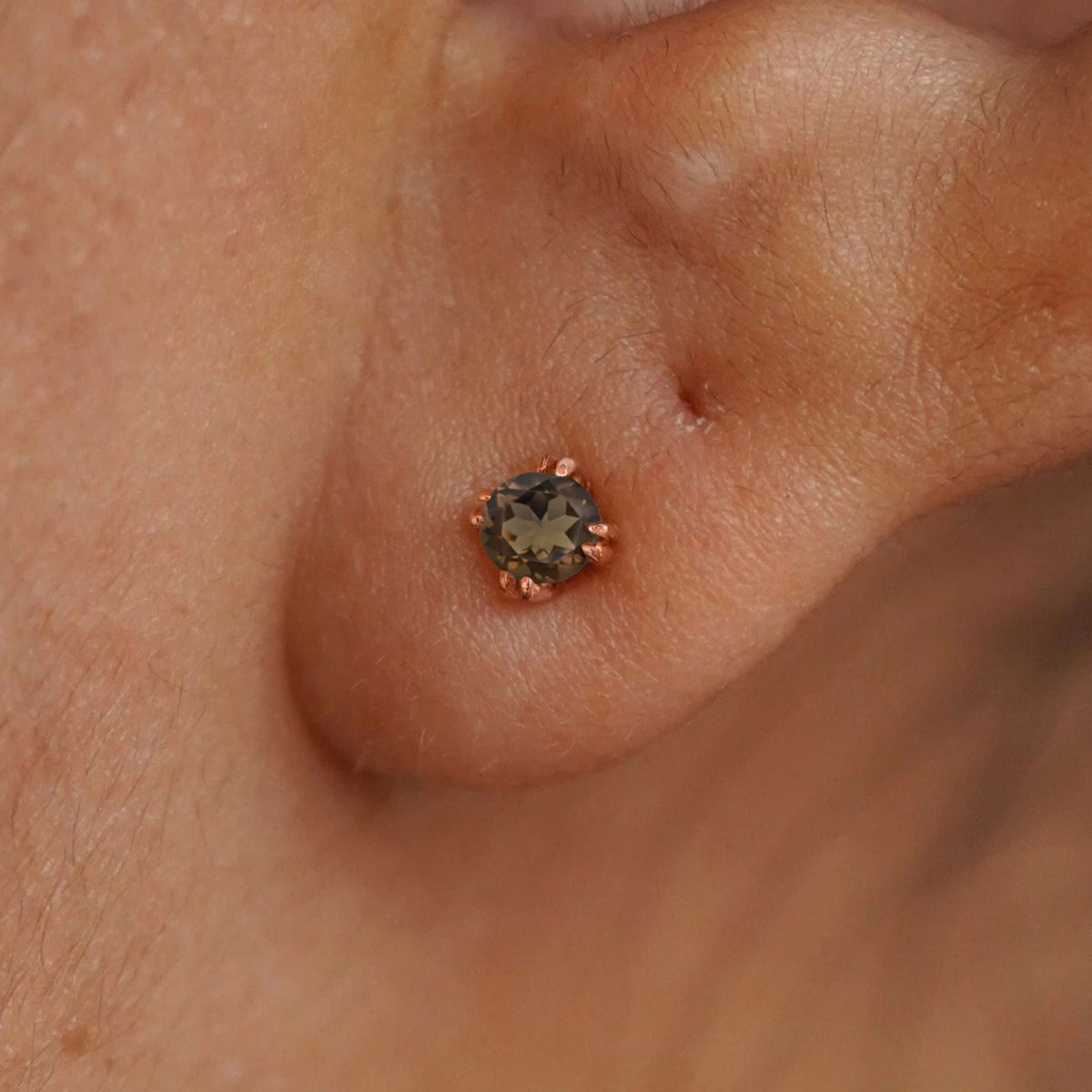 Close up view of a model's ear wearing a 14k rose gold Rose Quartz Earring