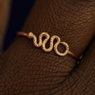 Close up view of a model's fingers wearing a 14k rose gold Snake Ring
