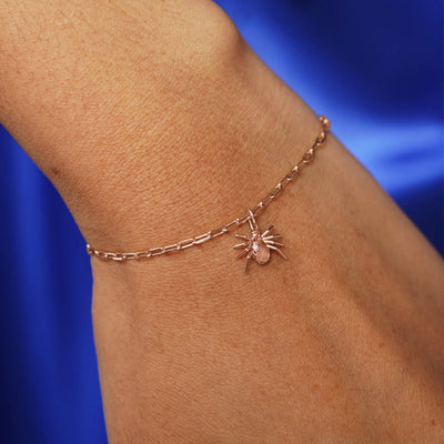 Close up view of a model's wrist wearing a rose gold Spider Charm on a Butch Chain Bracelet