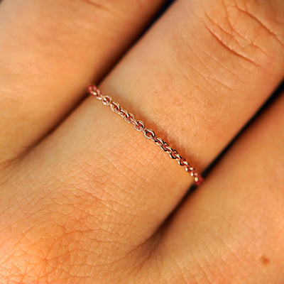 Close up view of a model's fingers wearing a 14k rose gold Thick Cable Ring