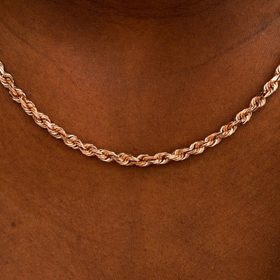 Close up view of a model's neck wearing rose gold thick rope chain