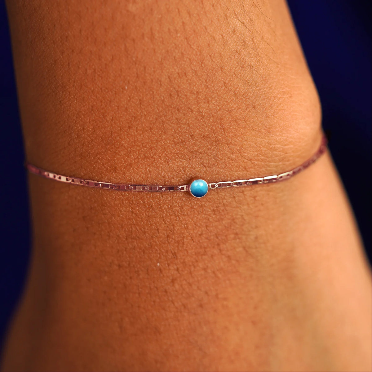 A model's wrist wearing a 14 karat rose gold Turquoise Bracelet