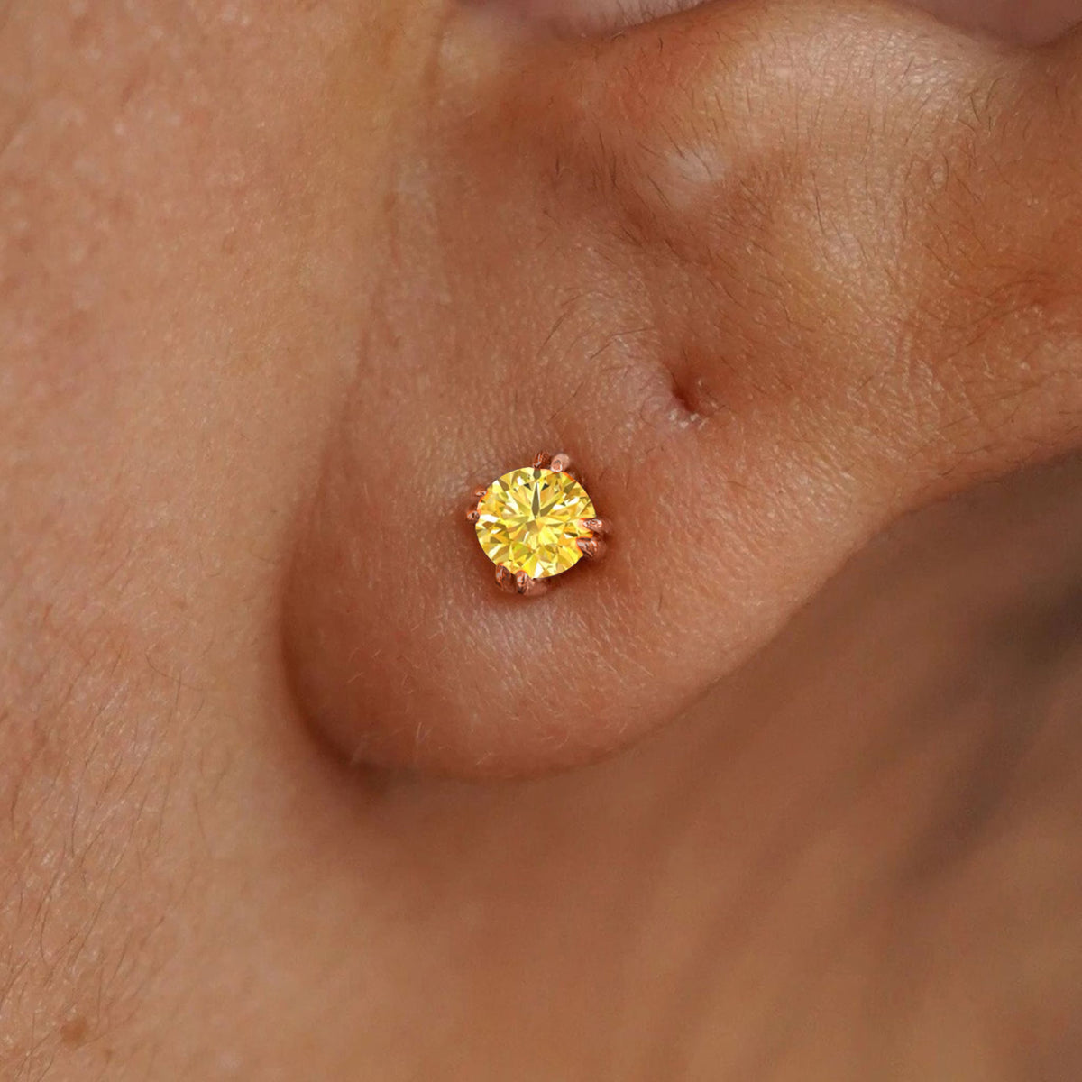 Close up view of a model's ear wearing a 14k rose gold Yellow Diamond Earring