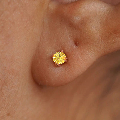 Close up view of a model's ear wearing a 14k rose gold Yellow Diamond Earring