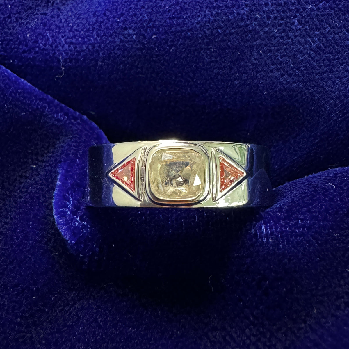 14k White Gold Bezel-set 0.76ct 5.5x5mm Cushion Salt-and-pepper Diamond w/ Triangle-cut Pink Lab Diamonds on 5mm Mirror Finish Band Custom Ring on a blue background