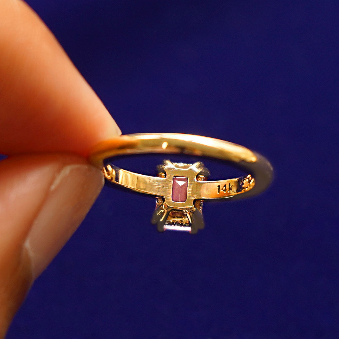 Underside view of a solid 14k gold emerald cut blush pink lab sapphire ring