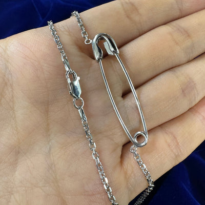 Silver pin cable chain necklace resting on models hand