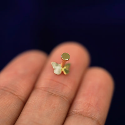 A Mini Butterfly Flatback laying face down on a model's finger tip to show the flatback