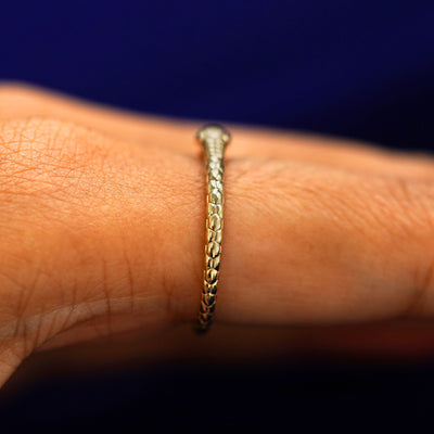 Alternate Side view of a Gemstone Ouroboros Snake Ring on a model's finger showing the back of the snake's head