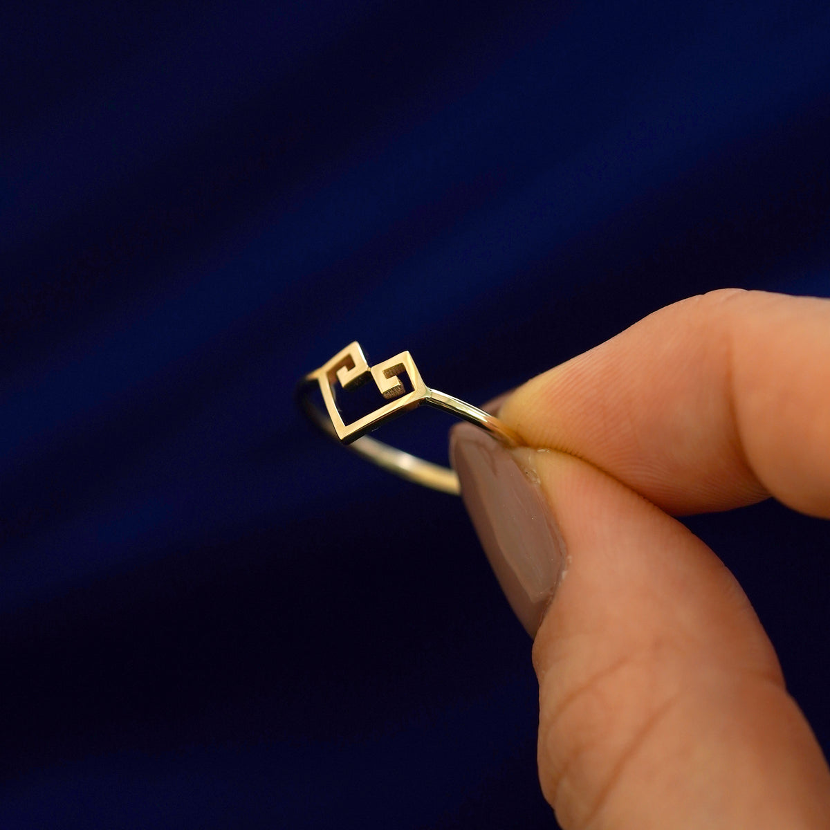A model holding a 14k gold Chere Heart Ring tilted to show the side of the ring