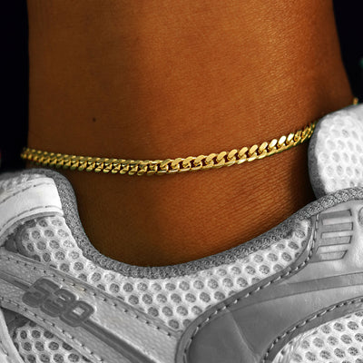 A model's ankle wear a 14k yellow gold Medium Miami Anklet