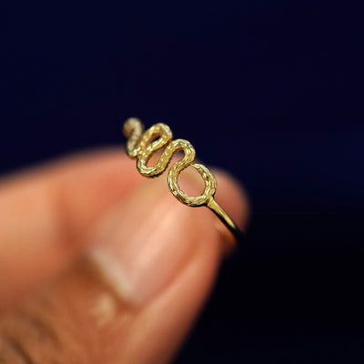 A model holding a Snake Ring tilted to show the details of the snake's tail