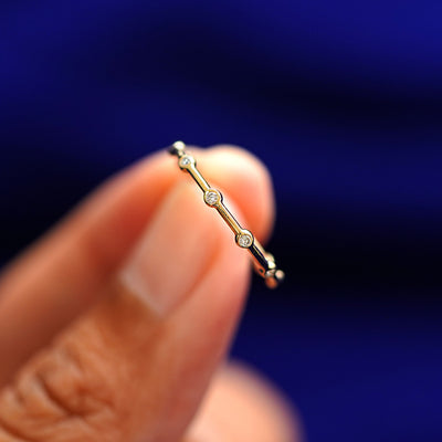 A model holding a Spaced Infinity Ring tilted to show the side of the ring