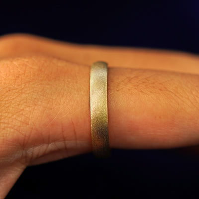 Side view of a Curvy Stardust Band on a model's finger