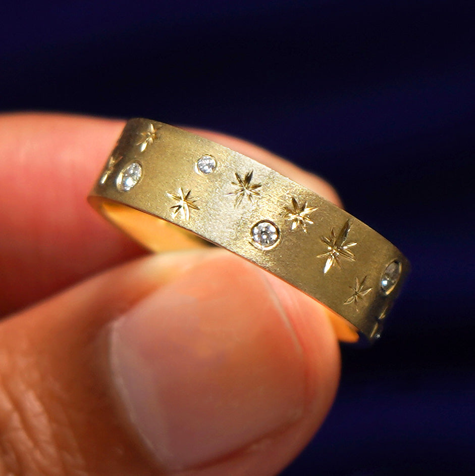A model holding a Stars and Diamonds Band tilted to show the details of the ring