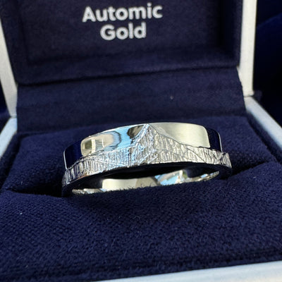 A photo of a 14k White Gold Swiss Alps Mountain w/ Custom Texture on 5mm Custom Band in a blue ring box